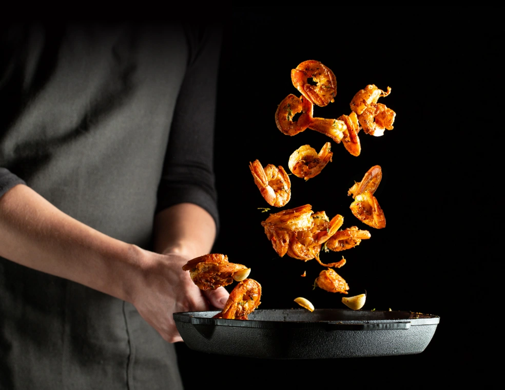 Experienced Chefs Wearing Black Apron And Cooking Chrisp Brown Golder Shrimp In An Non Stick Pan